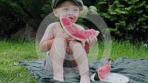 Little boy eating slice of watermelon outdoors.