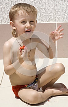 Little boy eats berries photo