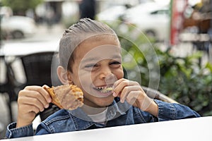 Little boy eats french fries and chicken