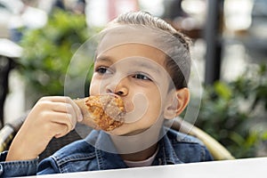 Little boy eats fried chicken
