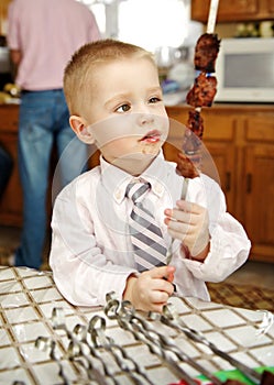 Little boy eats shish kebab