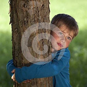 Little boy embracing a tree