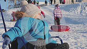 Little boy enjoying a sleigh ride. Child sledding. Toddler kid riding a sledge. Children play outdoors in snow.