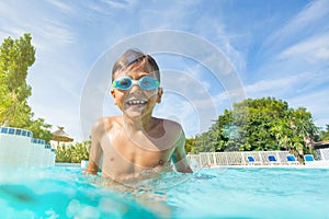 Little boy enjoying summer playing in the pool