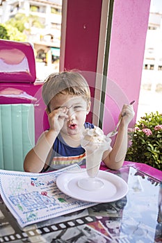 Little boy enjoys Ice Cream in old fashioned parlor.