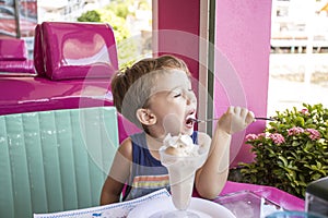 Little boy enjoys Ice Cream in old fashioned parlor.