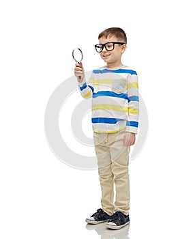 Little boy in eyeglasses with magnifying glass