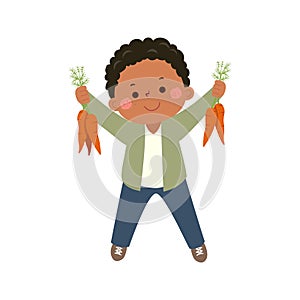 Little boy farmer holding carrots