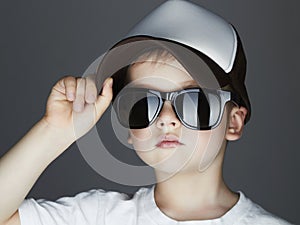 Little boy. fashion children.handsome in sunglasses and Tracker Hat. Child in Cap