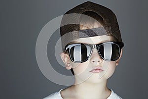 Little boy. fashion children.handsome in sunglasses and Tracker Hat. Child in Cap