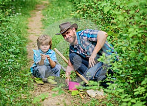 Little boy and father in nature background. Gardening tools. Spring gardening routine. Planting flowers. Gardening hobby