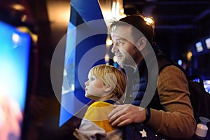 Little boy with father watching fishes in seaquarium