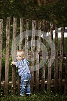 Little boy with fence outdoors