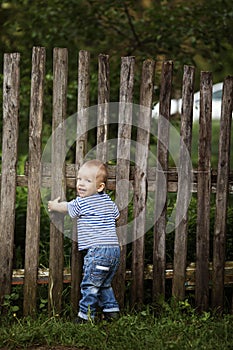 Little boy with fence outdoors