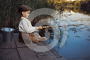 Little boy fishing at sunset