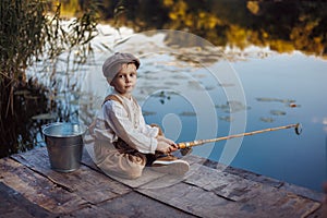 Little boy fishing at sunset