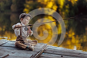 Little boy fishing at sunset