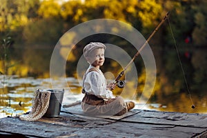 Little boy fishing at sunset