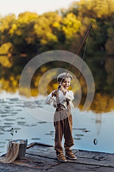 Little boy fishing at sunset