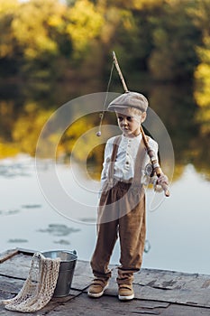 Little boy fishing at sunset