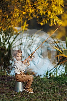 Little boy fishing at sunset