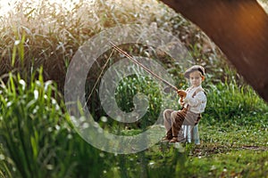 Little boy fishing at sunset