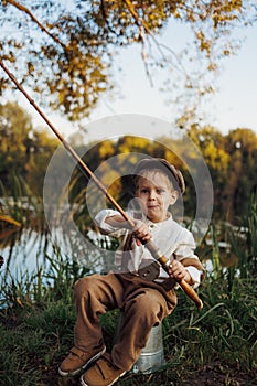 Little boy fishing at sunset