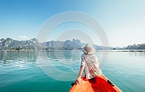 Little boy floating on kayak on Cheow Lan Lake, Khao Sok national park, Thailand