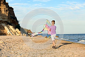 Little boy flying kite near sea