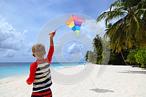 Little boy flying a kite on tropical beach