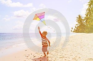 Little boy flying a kite on tropical beach