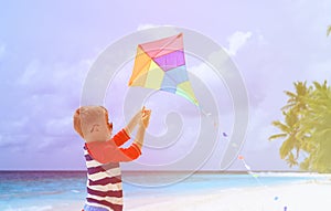 Little boy flying a kite on tropical beach