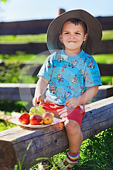 Little boy in funny hat with fruits