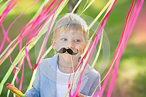 Little boy with funny paper mustache