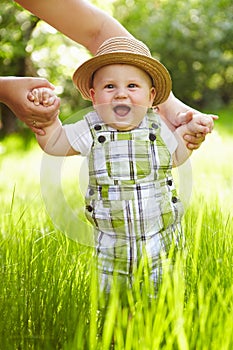 Little boy in the garden. Walking outdoors.