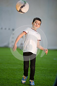 A little boy getting the ball on the field playing football