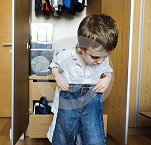 Little boy getting dressed by himself