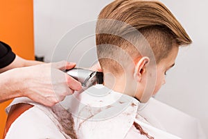 Little boy getting haircut by barber