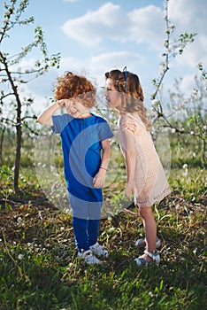 Little boy and girl in blooming garden