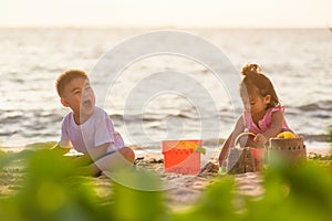 Little boy and girl brother and sister family playing sand