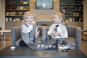 Little boy with girl in business clothes play with