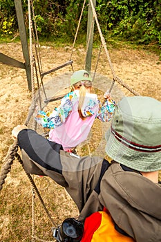 Little boy and girl climbing on the net leddar in adventure park