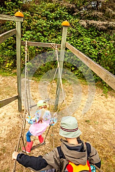 Little boy and girl climbing on the net leddar in adventure park