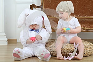 Little boy and girl in costumes bunny sitting on photo