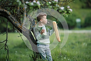 Little boy with girl drink milk and eat a loaf of bread on a haystack in a village at sunset