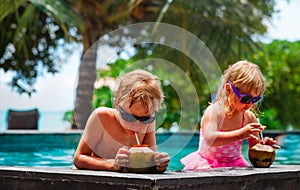 Little boy and girl drinking coconut cocktail on beach resort