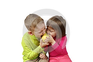 Little boy and girl eat one apple simultaneously