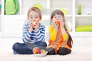 Little boy and girl eating apples
