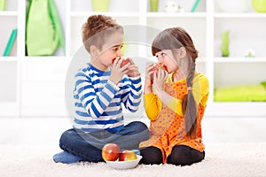 Little boy and girl eating apples