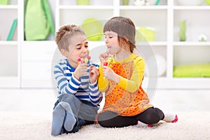 Little boy and girl eating lollipop